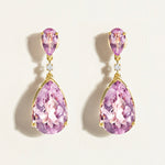 Pair of statement festive light purple amethysts large teardrop earrings in 14 k gold with diamonds on a light beige background