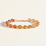 Bracelet with multicolored citrine gemstones on a light beige background