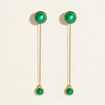 Pair of glossy green malachite gemstone in gold bezel earrings with detachable solid gold chains on a white background