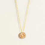 14 k Gold everyday necklace with a round peach morganite pendant with diamond halo on a light beige background