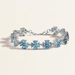 White gold bracelet with blue gemstones on a light beige background