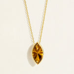 14/18 karat Gold chain necklace with a large marquise-shaped dark yellow olive quartz gemstone pendant on a light background
