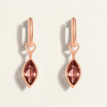 Rose gold huggies earrings with marquise-shaped tourmaline gemstones on a light background