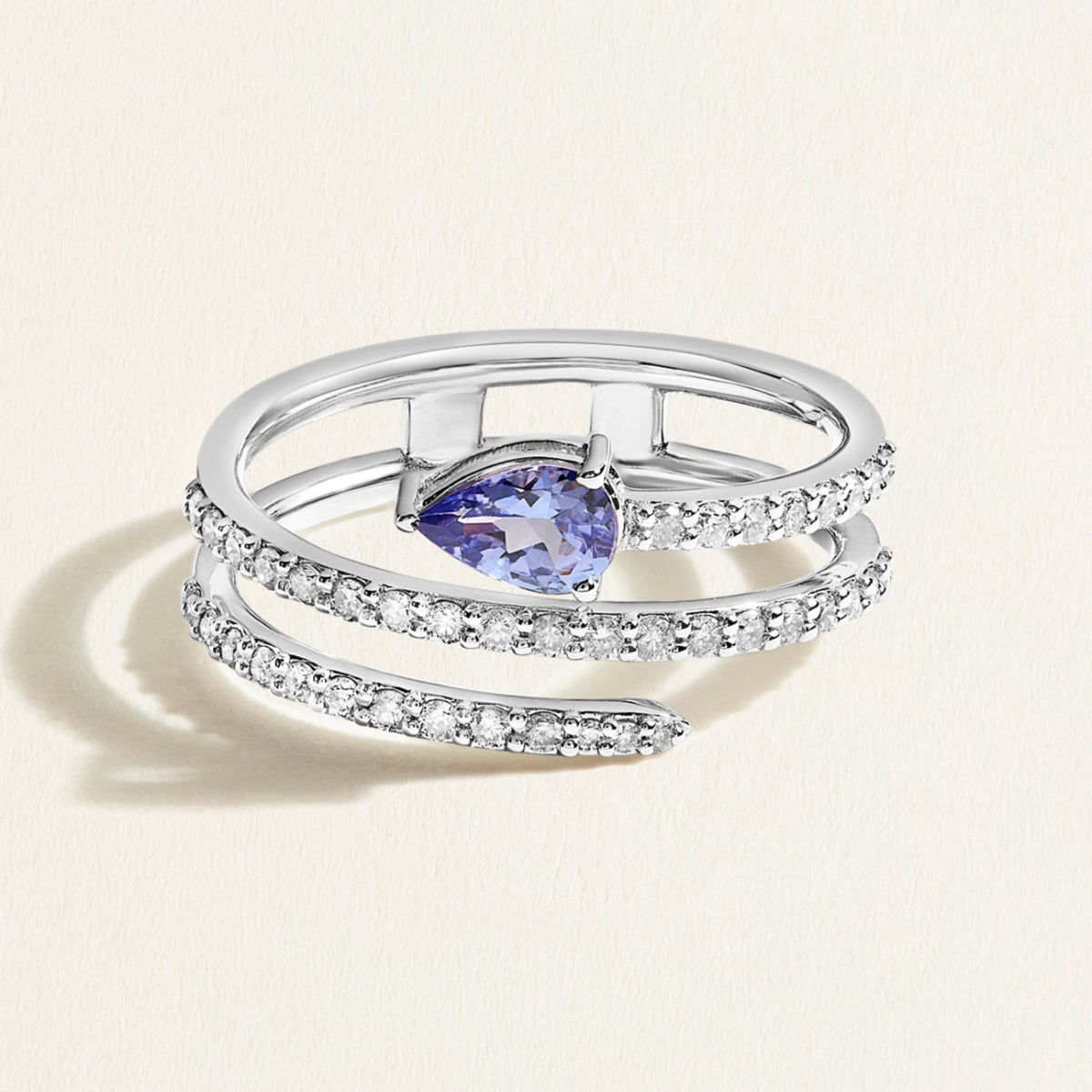 A modern ring in white gold with a spiral of diamonds crowned with a vivid deep blue tanzanite.