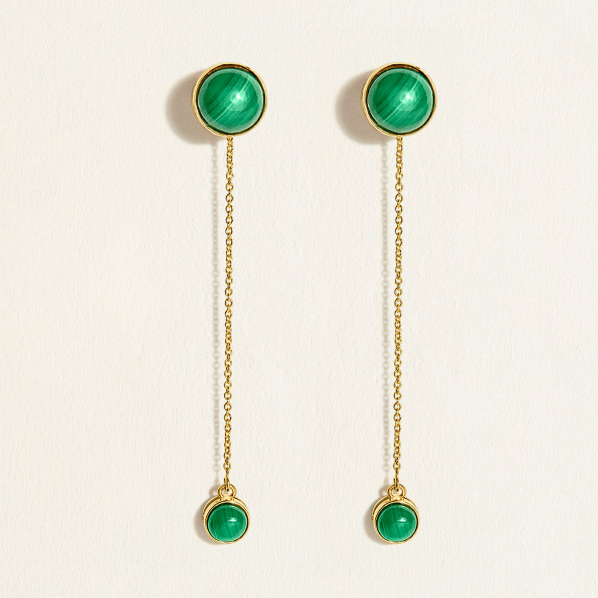 Pair of glossy green malachite gemstone  in gold bezel earrings with detachable solid gold chains on a white background