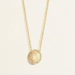 14k Gold everyday chain necklace with an opal pendant with diamond halo on a light beige background