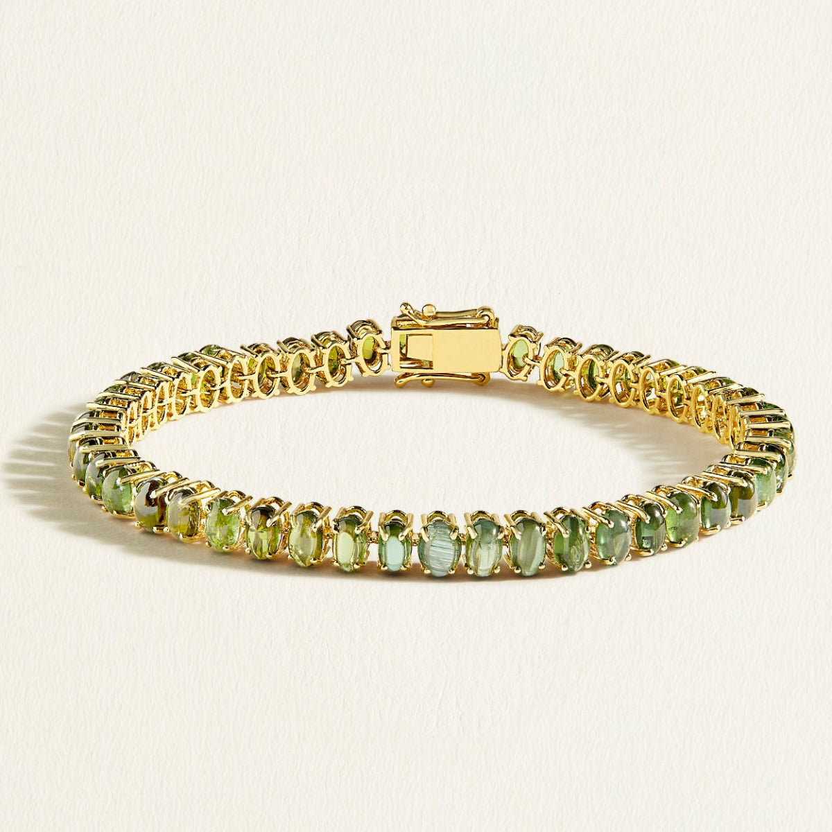 A solid 14 k gold tennis bracelet with upright oval cabochon green tourmalines in 13 carats, evoking the freshness of garden dew.