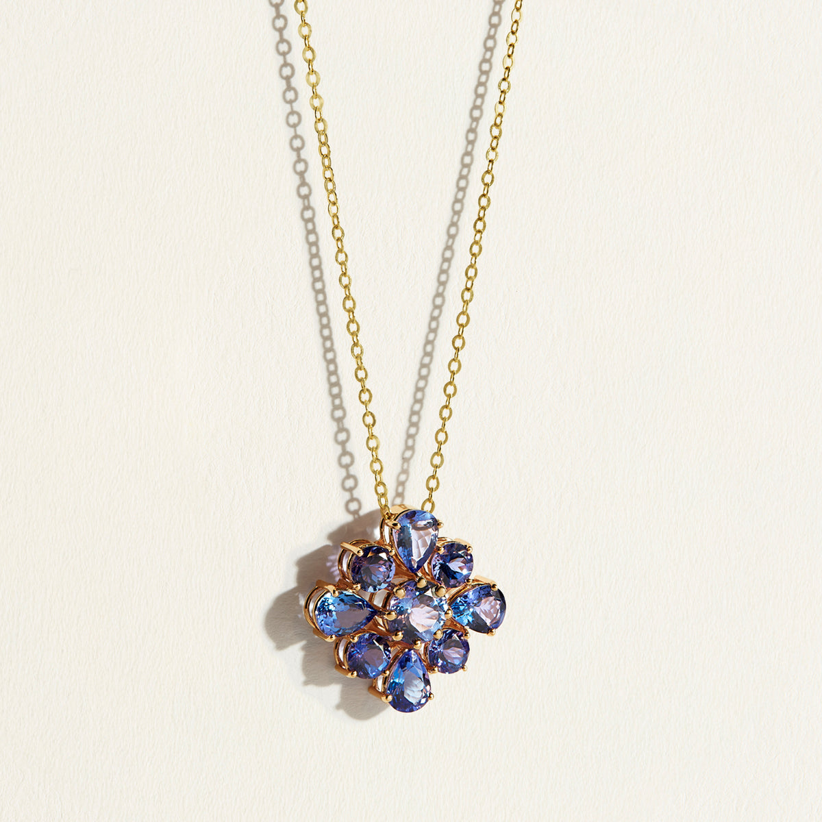 A 10 carats violet-blue bloom of natural tanzanites clustered into a singular, luminous flower pendant with a necklace