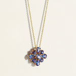 A 10 carats violet-blue bloom of natural tanzanites clustered into a singular, luminous flower pendant with a necklace
