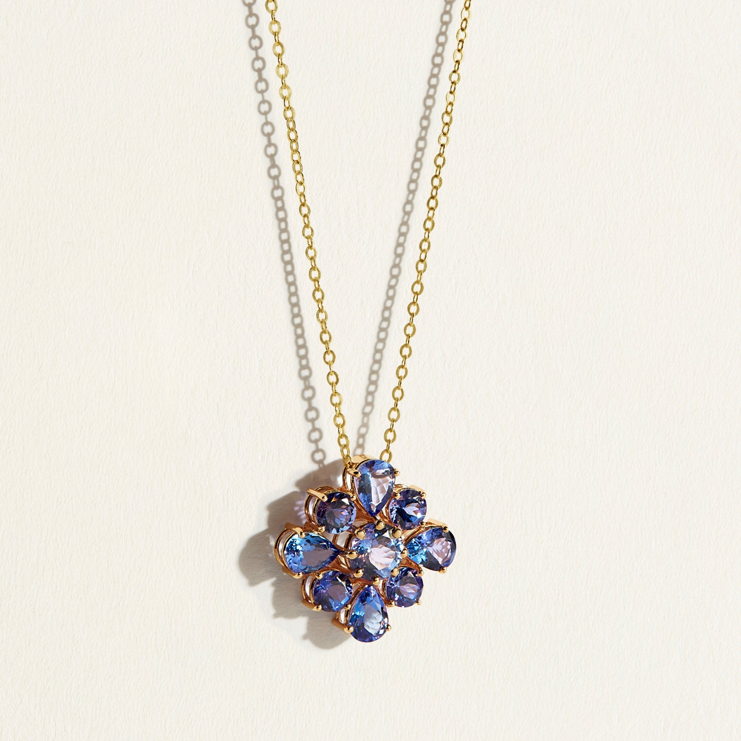 A 10 carats violet-blue bloom of natural tanzanites clustered into a singular, luminous flower pendant with a necklace