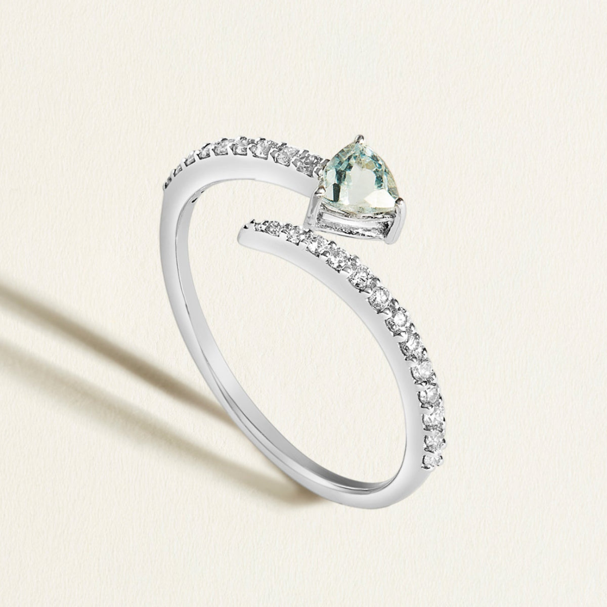 18k white gold open ring with diamond spiral with a blue aquamarine gemstone on a light background