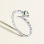 18k white gold open ring with diamond spiral with a blue aquamarine gemstone on a light background