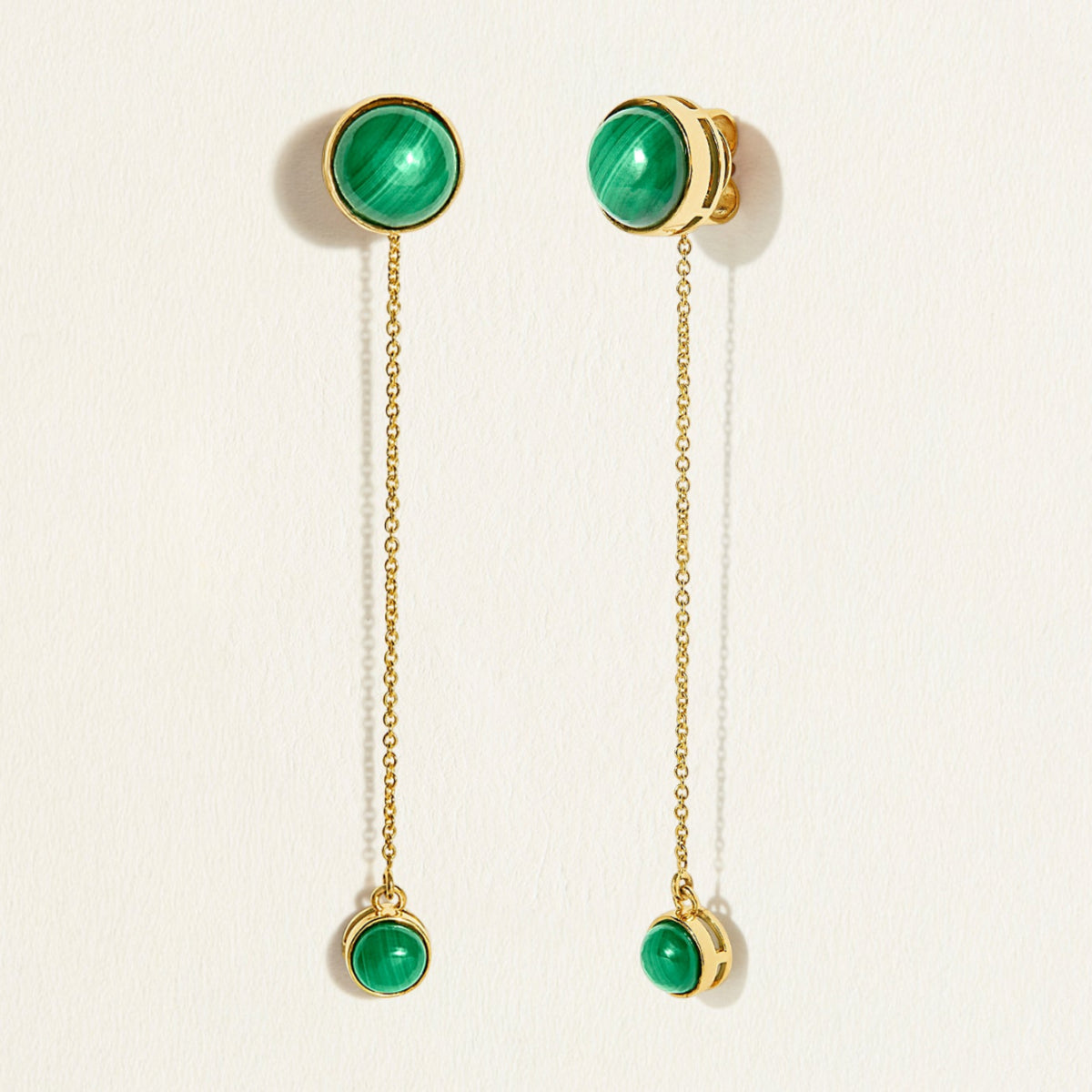 14k Gold chain dangler earrings with green malachite gemstones  on a light beige background