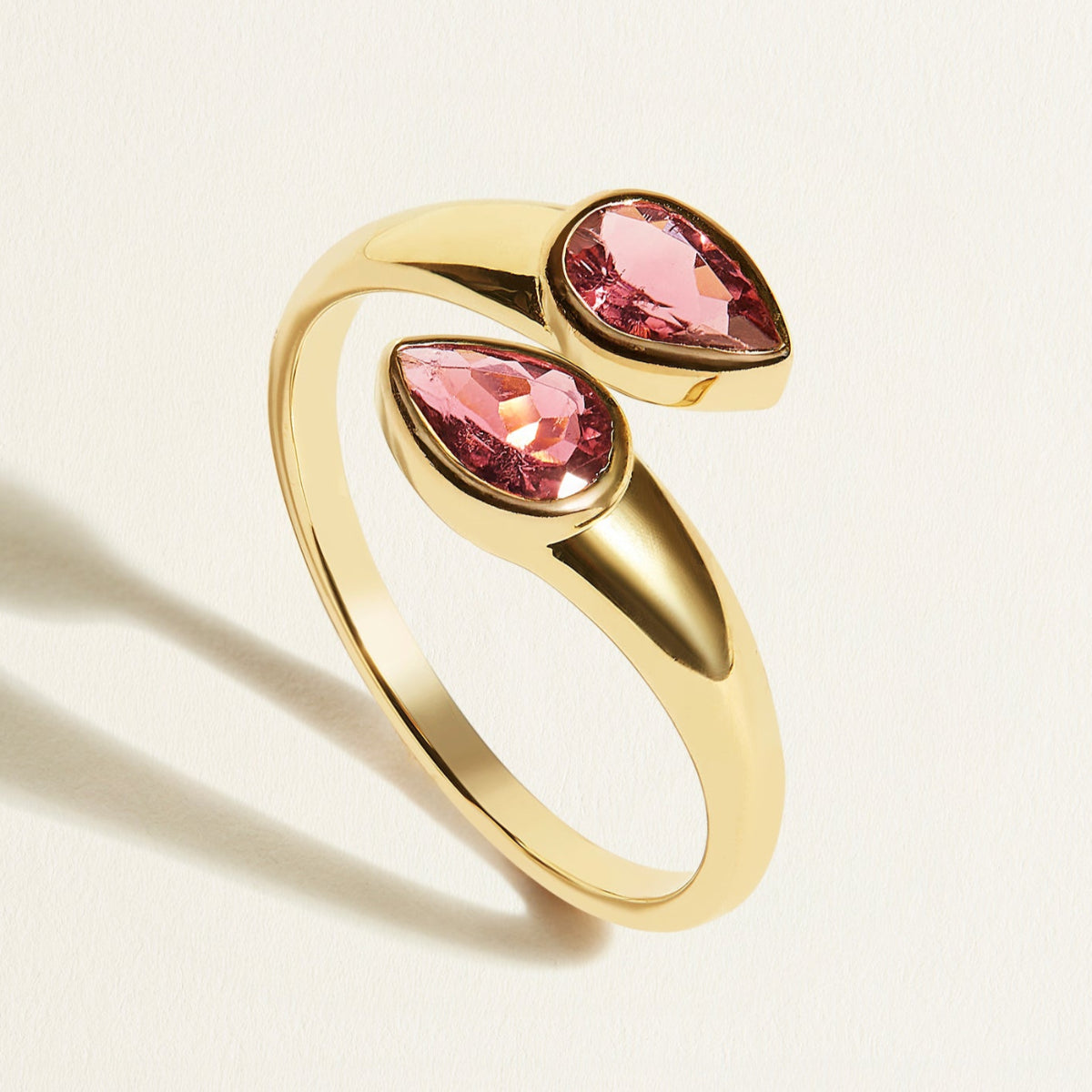 Gold toi et moi ring with pink tourmalines in pear shape gemstones on a light background