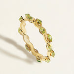 14/18 k gold thin eternity ring with a wave band with small green peridots in marquise shape