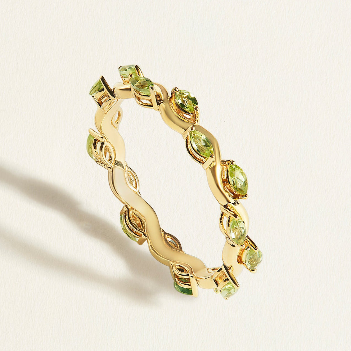 14/18 k gold thin eternity ring with a wave band with small green peridots in marquise shape