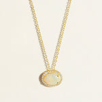 14k Gold everyday chain necklace with an opal pendant with diamond halo on a light beige background