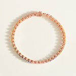 Rose gold tennis bracelet with rainbow sapphire stones on a white background