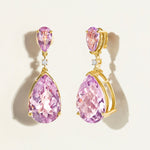 Pair of statement festive light purple amethysts large teardrop earrings in 14 k gold with diamonds on a light beige background