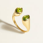 Gold signet open ring with green tourmaline cabochon gemstones on a light background