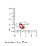 White minimal gold ring with  two red tourmaline gemstones and small diamonds  measurement against a ruler on a white background