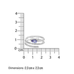 White gold diamond spiral ring with a blue tanzanite gemstone next to a ruler showing its dimensions on a white background