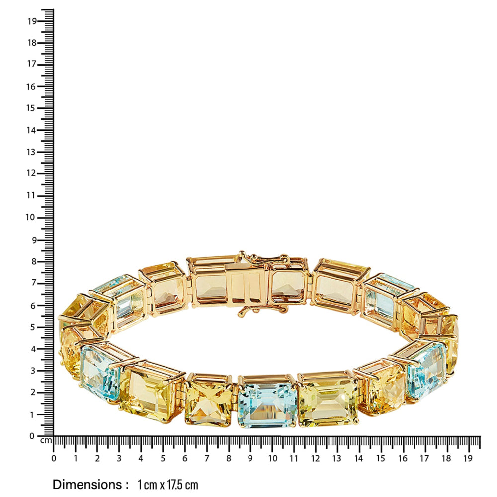 Gold bracelet with yellow beryl, blue topaz, lemon quartz gemstones next to a ruler for size reference