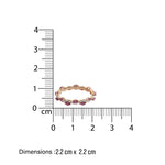 sleek eternity Ring with diamond and amethyst gemstones in wave pattern  next to a ruler on a white background