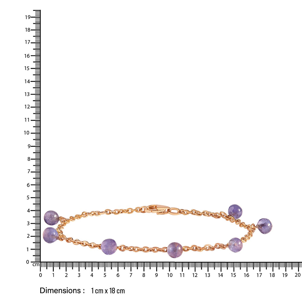 Gold bracelet with blue beads on a white background with a ruler for scale.
