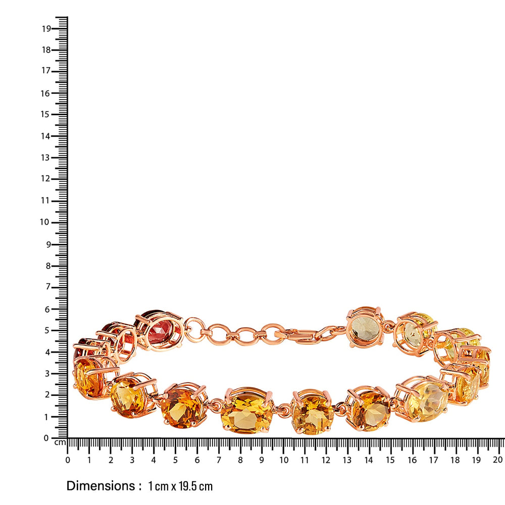 Gold bracelet with colorful citrine stones next to a ruler on a white background