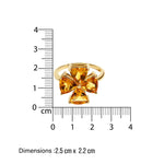Gold ring with clover citrine stones next to a ruler on a white background
