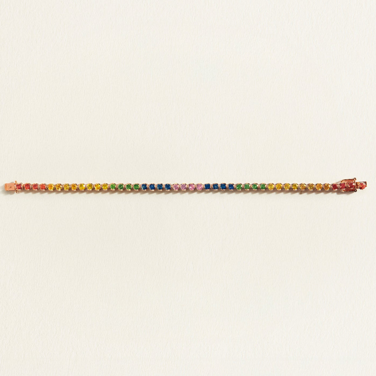 rainbow sapphire gemstone tennis bracelet on a light beige background