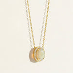 14k Gold everyday chain necklace with an opal pendant with diamond halo on a light beige background