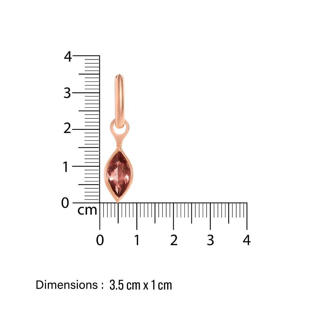 Rose gold huggy earring with marquise-shaped tourmaline gemstone next to a ruler on a white background