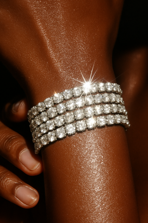 Close-up of a person's wrist wearing a sparkling tennis diamond bracelets against a dark background.