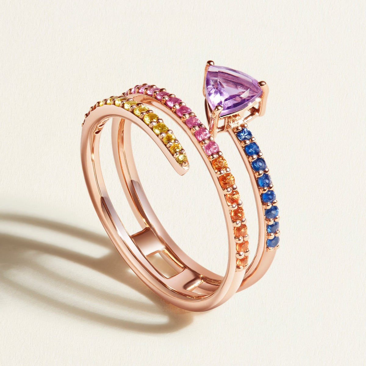 rose gold spiral ring in rainbow sapphires with purple amethyst on top