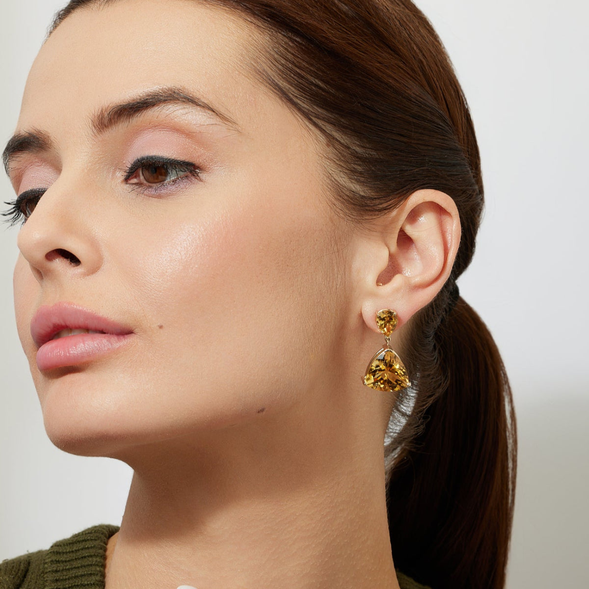 Woman wearing elegant minimal gold earrings with large citrine drops 