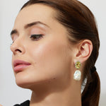 Woman wearing oval peridot and baroque pearl large earrings 