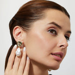 Woman wearing gold cocktail green amthyst earrings with baroque pearl