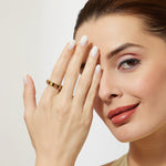 Woman wearing a citrine and smoky quartz pears eternity ring in gold