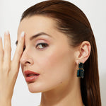 woman wearing large london blue topaz cocktail earrings in gold