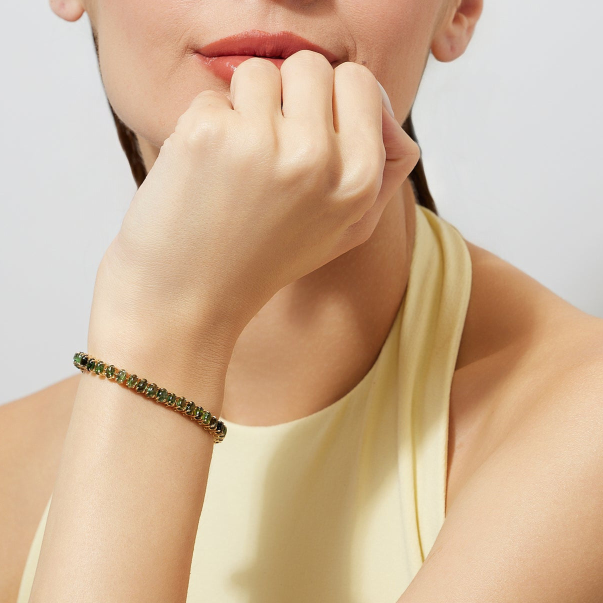 woman wearing a green tourmaline tennis bracelet