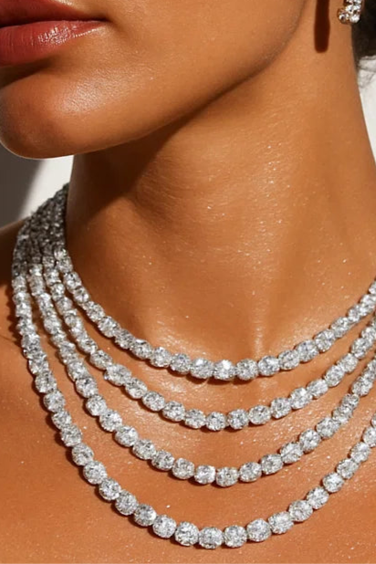 Woman wearing a diamond necklace and earrings against a neutral background